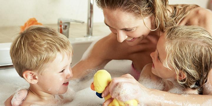 Kvinde og børn i bad med varmt vand fra Metro Therm varmtvandsbeholder